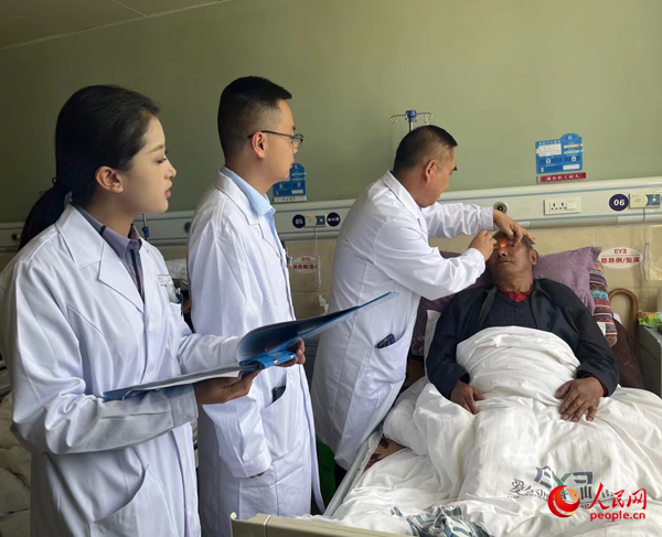 董光明（左三）帶領(lǐng)醫(yī)生對(duì)患者進(jìn)行術(shù)前檢查。人民網(wǎng)記者 杜燕飛攝