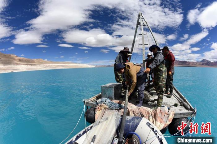 科考隊(duì)員在湖泊鉆探平臺(tái)上小心搬運(yùn)采集的巖芯樣品。　<a target='_blank' ><p  align=