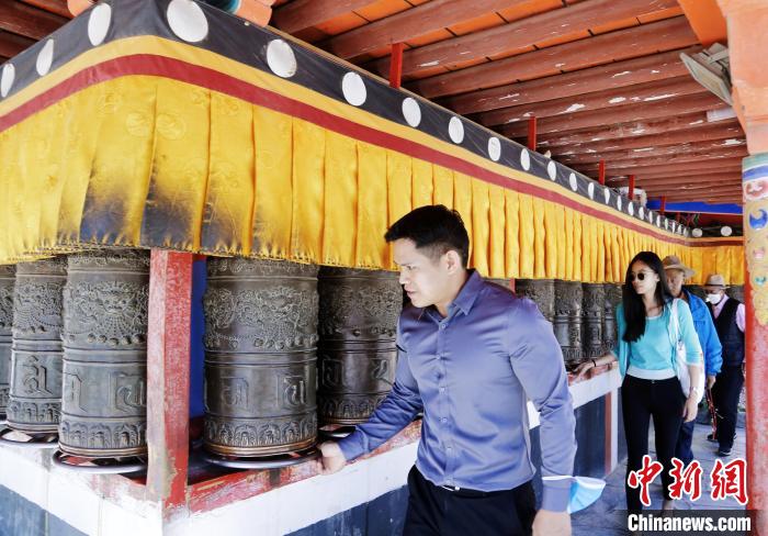 圖為外籍嘉賓體驗(yàn)藏族傳統(tǒng)轉(zhuǎn)經(jīng)筒。　馬銘言 攝