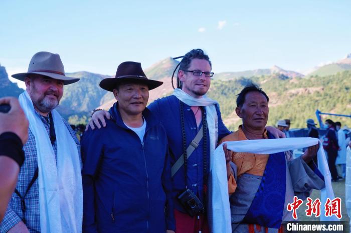 圖為當(dāng)?shù)孛癖娕c外籍?dāng)z影師合影留念。　馬銘言 攝