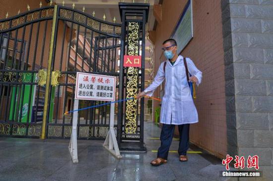 資料圖：?？诮?jīng)濟學院的工作人員在學生宿舍樓入口消毒。 中新社記者 駱云飛 攝