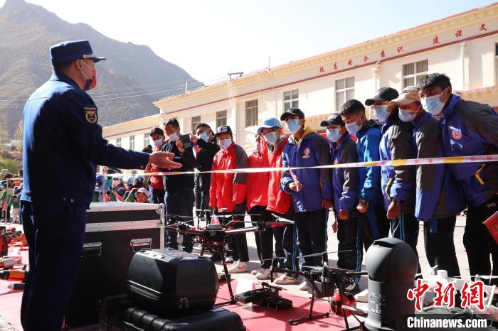 圖為消防指戰(zhàn)員為學(xué)生講解、演示先進救援裝備?！≮w琳 攝