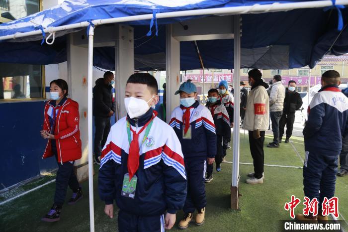 圖為學生測量體溫后進入校園?！●R銘言 攝