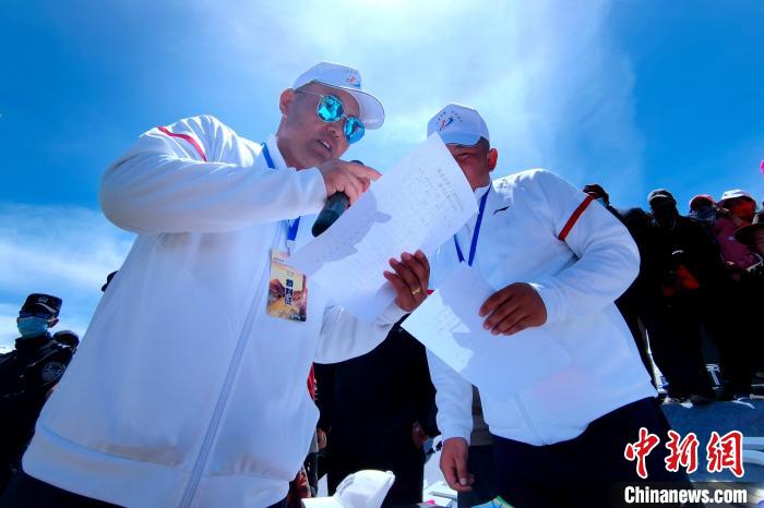 圖為裁判員統(tǒng)計牧民運動項目比賽成績。　李雋 攝