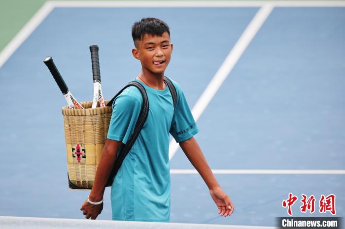 王發(fā)背著背簍在賽場上?！±罱ㄋ?攝