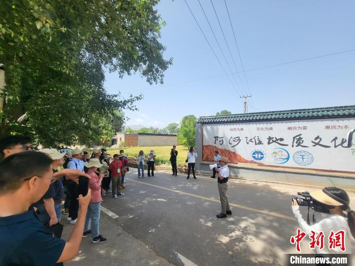 圖為中國地質(zhì)大學(xué)(北京)教授張緒教介紹村落情況。　胡友軍 攝