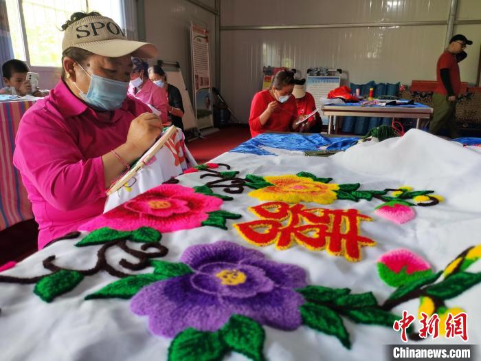 圖為婦女制作青繡?！?zhí)砀?攝