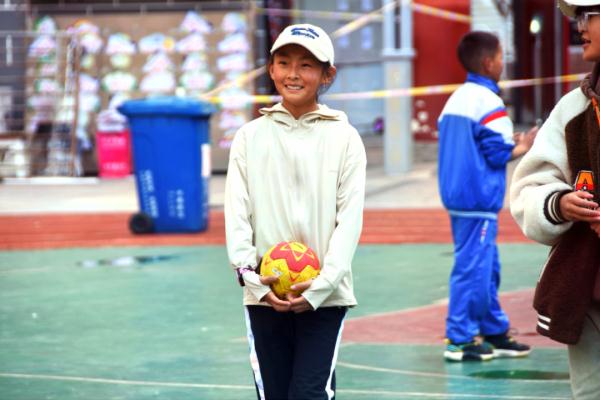 在高原上教孩子們打手球，“慢慢兒來，甭著急！”