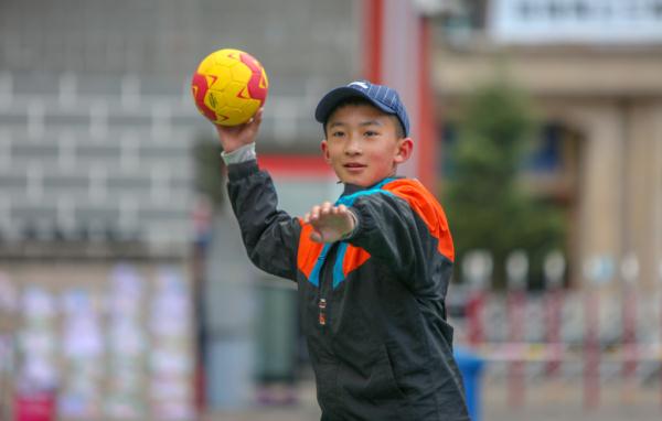 在高原上教孩子們打手球，“慢慢兒來，甭著急！”