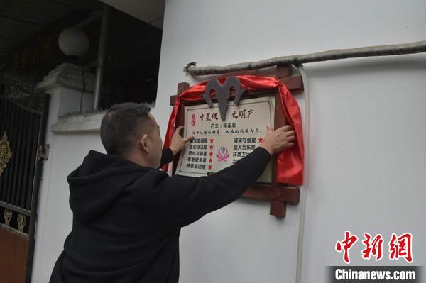 桂溪鎮(zhèn)渭溝村政府工作人員為“十星級(jí)文明戶”掛上牌匾?！钣?攝