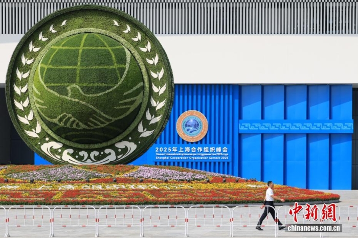 8月31日，天津，一名工作人員從2025年上海合作組織峰會主會場外的景觀花壇旁經(jīng)過。當(dāng)日，2025年上海合作組織峰會在天津舉行。<a target='_blank' href='/'><p  align=