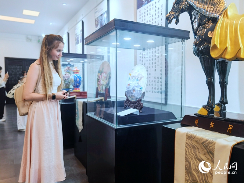 來自白俄羅斯的留學(xué)生喀秋莎駐足欣賞牡丹瓷。人民網(wǎng)記者 尚明楨攝