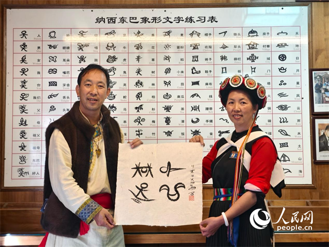 人民網(wǎng)“行進中國”云南調(diào)研采訪團走進麗江，和閏元現(xiàn)場用東巴文寫下“行進中國”。人民網(wǎng)記者 符皓攝