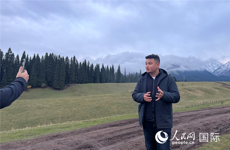 在庫爾德寧，吾買爾江被雪山美景震撼，即興錄制了短視頻作品。人民網(wǎng)記者曾書柔攝