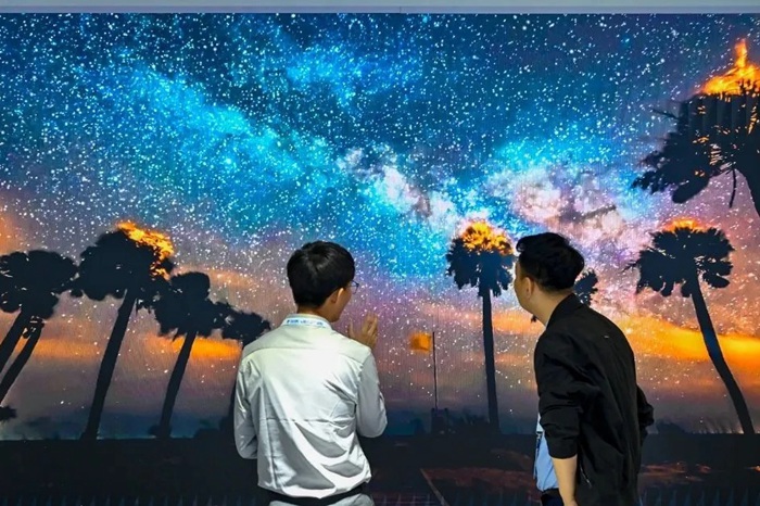 長春光博會希達電子展區(qū)，一位工作人員正在給一位觀眾講解。（長春新區(qū)供圖）