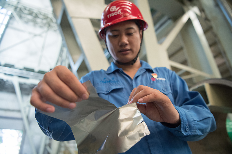 2018年8月8日，山西省太原市，太鋼精密帶鋼公司工作人員用手撕開不銹鋼。