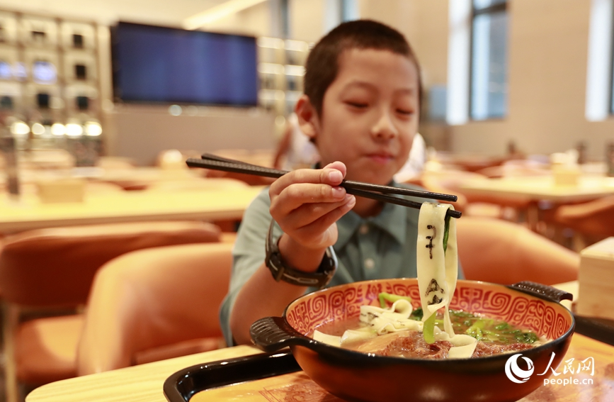 殷墟博物館推出的甲骨文面深受游客喜愛。人民網(wǎng)記者 慎志遠(yuǎn) 攝