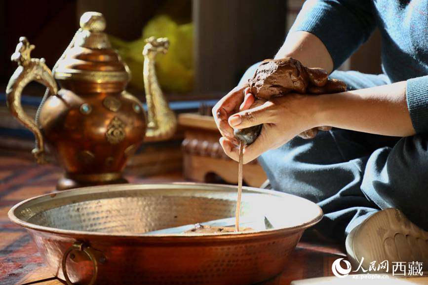 牛角鉆孔，將木泥擠出。人民網(wǎng)記者 次仁羅布攝