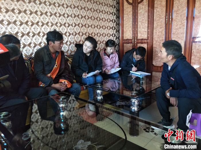 圖為調(diào)查組工作人員正在入戶調(diào)查?！∑钤鲚?攝