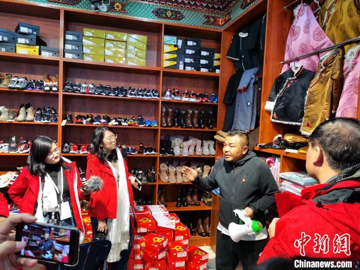 圖為中外媒體在玉樹州玉樹市甘達(dá)村采訪?！?zhí)砀?攝