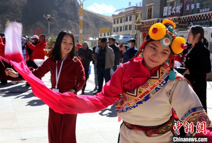 圖為中外記者向當(dāng)?shù)孛癖妼W(xué)習(xí)民族歌舞文化?！?zhí)砀?攝