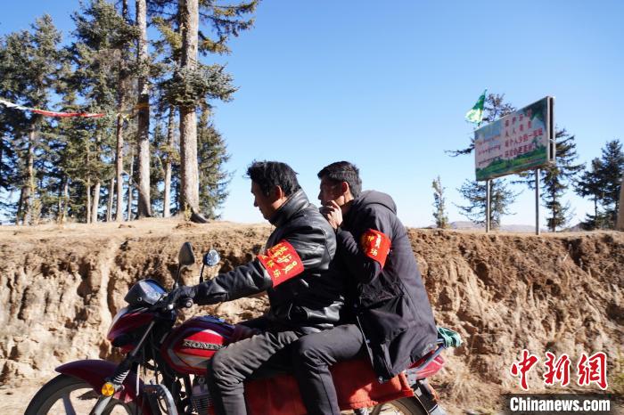 圖為同事騎摩托車載著桑杰加(后)前往林場。　馬銘言 攝