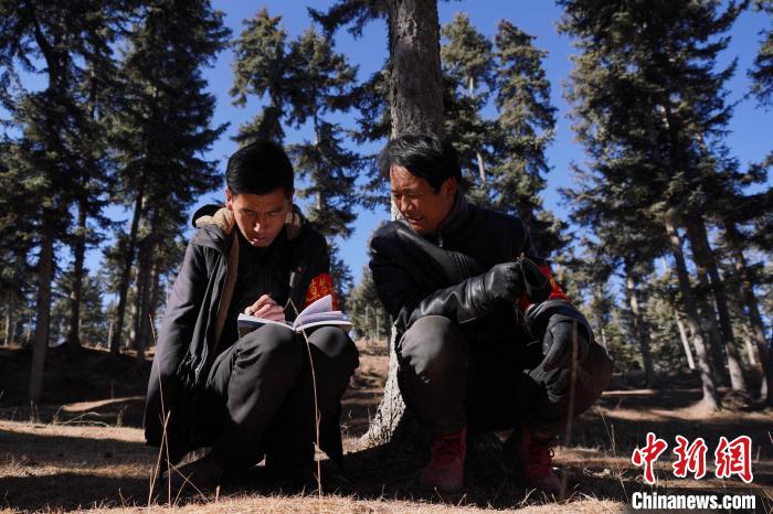 圖為桑杰加(左)和同事記錄巡查結(jié)果?！●R銘言 攝