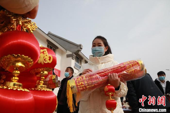 27日，蘭州新區(qū)為舟曲避險搬遷移民送“春節(jié)包”，楊周馬草前往領(lǐng)取，紅色寓意來年的日子紅紅火火。　魏建軍 攝