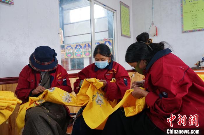 圖為工人正在制作哈達?！●R銘言 攝