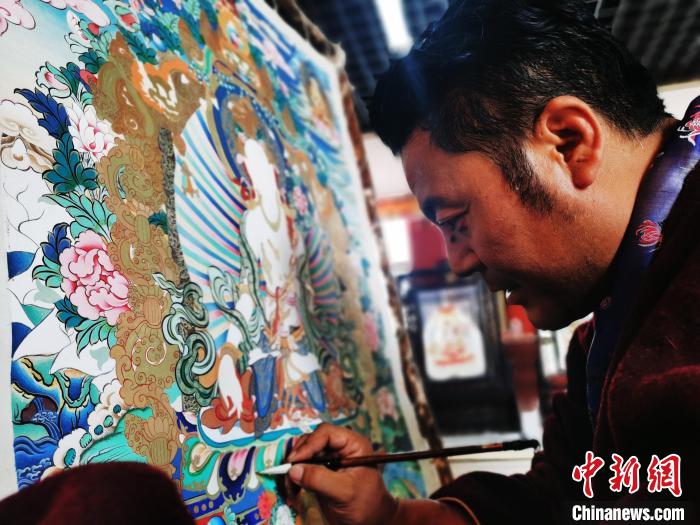 圖為久美尖措創(chuàng)作唐卡?！?zhí)砀?攝