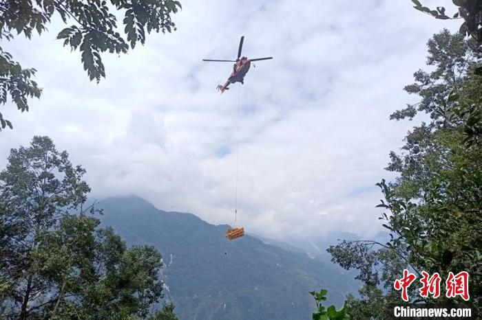 直升機(jī)起飛將搶修塔材運(yùn)往海拔1950米的110千伏唐下線29號(hào)塔位。　徐慶明 攝