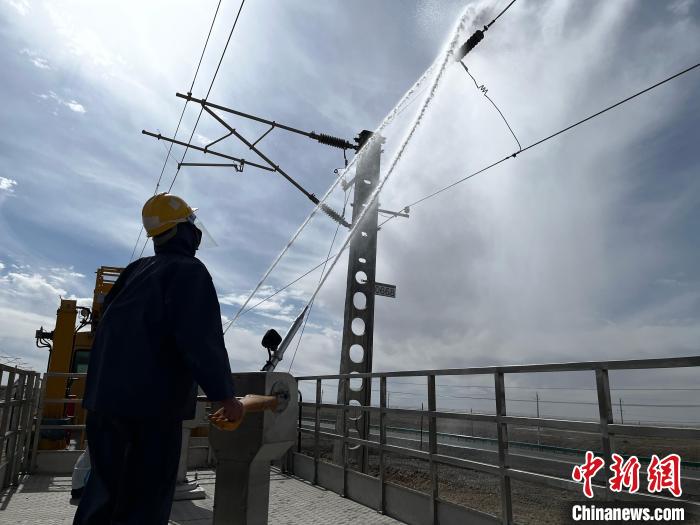 圖為高壓水槍的水柱沖洗絕緣子串。　高啟宏 攝