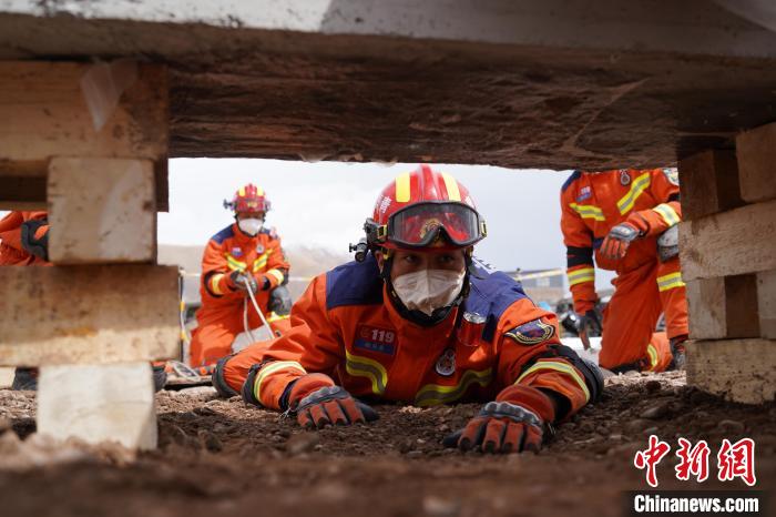 圖為地震實戰(zhàn)拉動現(xiàn)場，參演人員正在進行頂撐救援項目?！∮駱湎拦﹫D