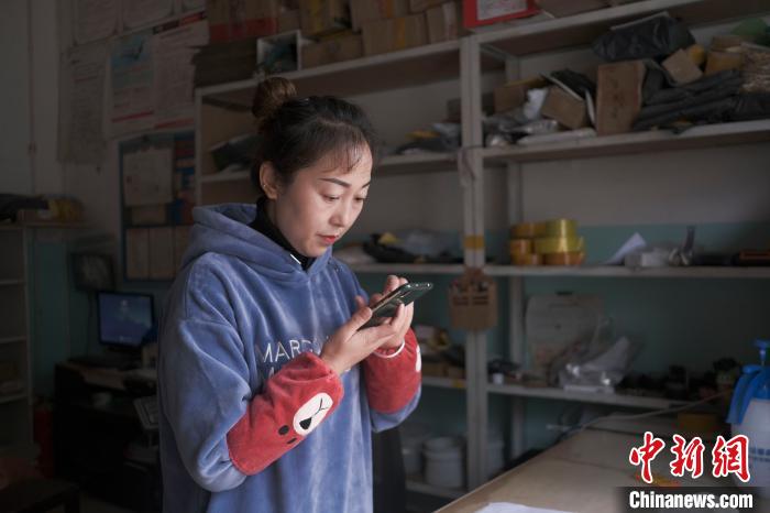 正在快遞站點(diǎn)內(nèi)忙碌的楊莉春。　何蓬磊 攝