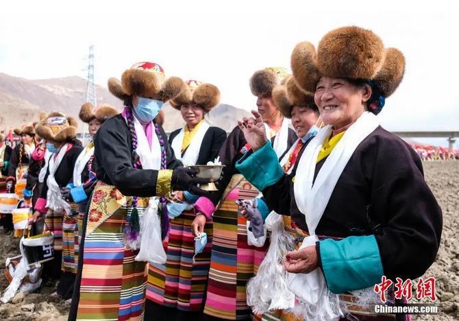 資料圖：西藏自治區(qū)拉薩市曲水縣才納鄉(xiāng)協(xié)榮村參加春耕儀式的村民互敬青稞酒。按照傳統(tǒng)，當(dāng)?shù)卮迕裆碇?jié)日盛裝，舉行隆重的儀式，祈福一年的豐收。<a target='_blank' ><p  align=