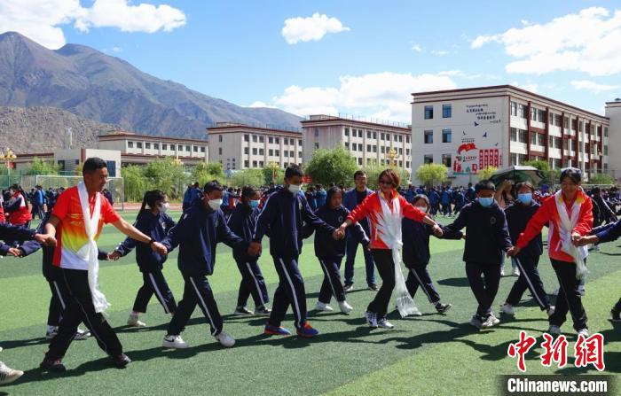 圖為世界冠軍與拉薩阿里地區(qū)高級中學學生一起跳鍋莊。　冉文娟 攝