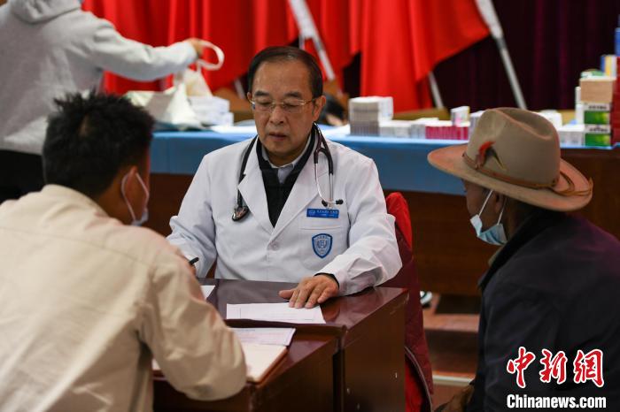 北京大學人民醫(yī)院心臟中心副主任、博士生導師王偉民為農(nóng)牧民問診。　江飛波 攝