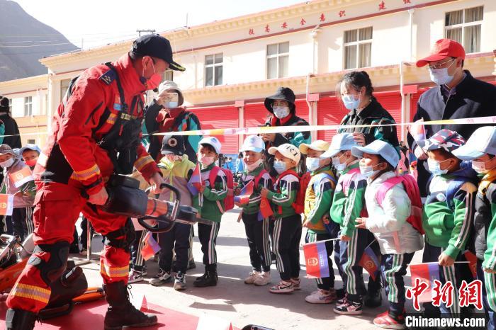 圖為消防指戰(zhàn)員為學生講解、演示先進救援裝備?！≮w琳 攝