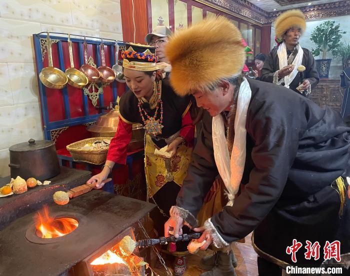 圖為人們?cè)诨鹕峡竟?jié)日美食“結(jié)達(dá)”?！∪轿木?攝