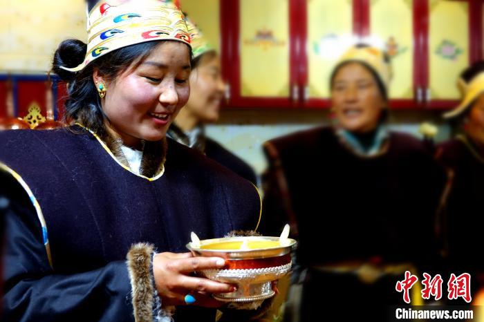 圖為藏族姑娘向客人敬酒?！∪轿木?攝