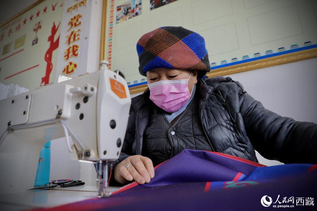 農(nóng)牧民專業(yè)合作社里的村民正在制作門簾。人民網(wǎng) 次仁羅布攝