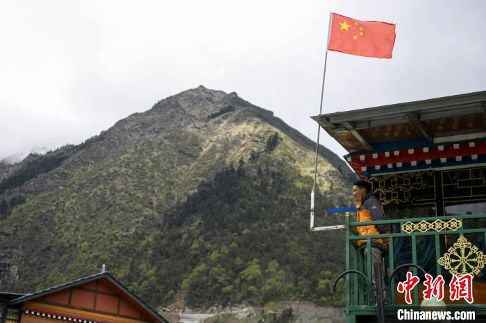 村民站在樓房上觀望?！钊A峰 攝