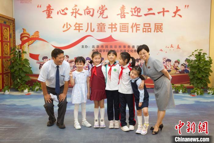 圖為與會嘉賓與入選畫作的“小作者”們在展覽上合影?！≈袊貙W研究中心供圖