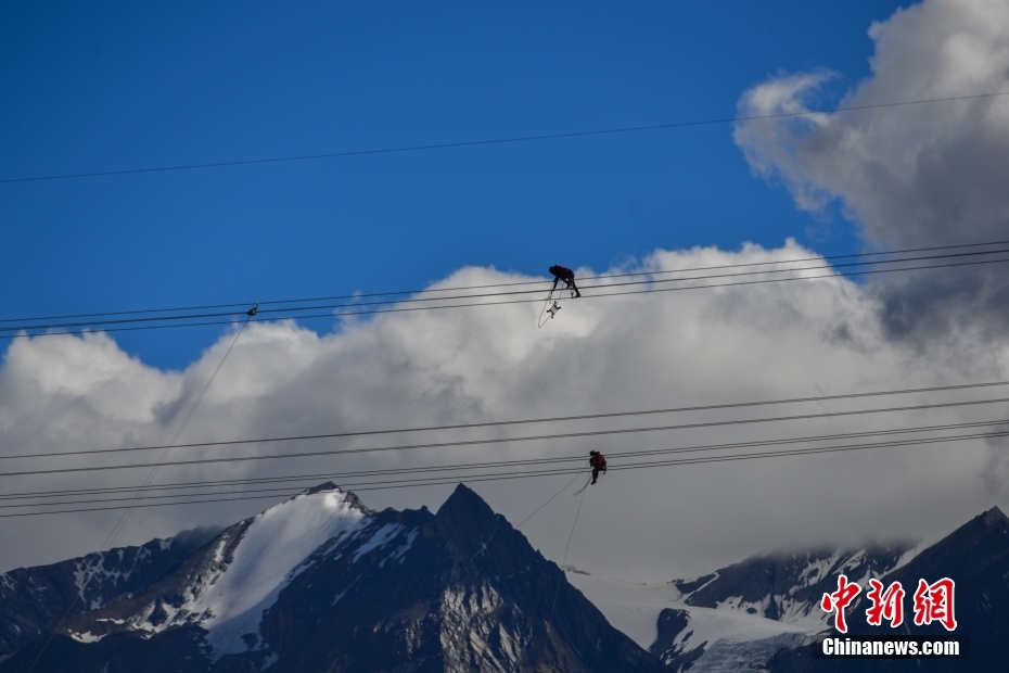 資料圖為2020年6月23日，西藏阿里聯(lián)網(wǎng)工程施工人員在日喀則希夏邦馬雪山附近進行走線作業(yè)，安裝絕緣設(shè)備。 <a target='_blank' href='/'><p  align=
