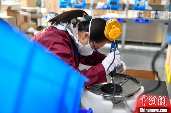 圖為工人正在組裝炊具?！∝暩聛硭?攝