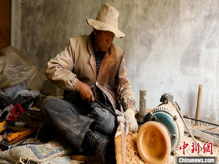 圖為手工藝人正在制作木碗。　 鄧海平 攝