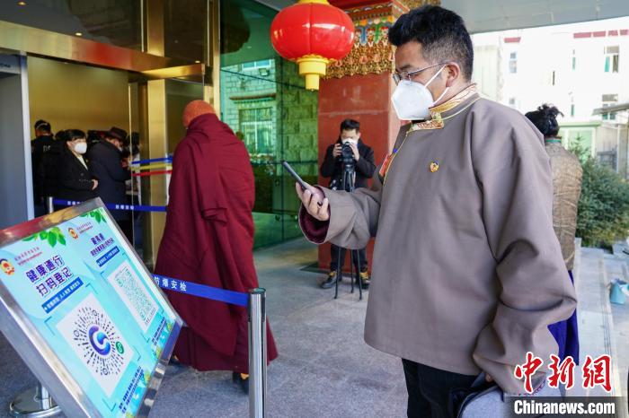 圖為政協(xié)委員掃場所碼進入會場?！〗w波 攝