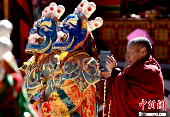 2月19日，正在拍攝跳神活動(dòng)的僧人?！±盍?攝