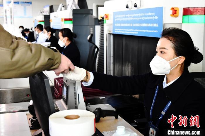 圖為機場工作人員為旅客辦理行李托運。　周航 攝