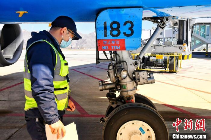 圖為機場工作人員進行相關(guān)檢查。　周航 攝